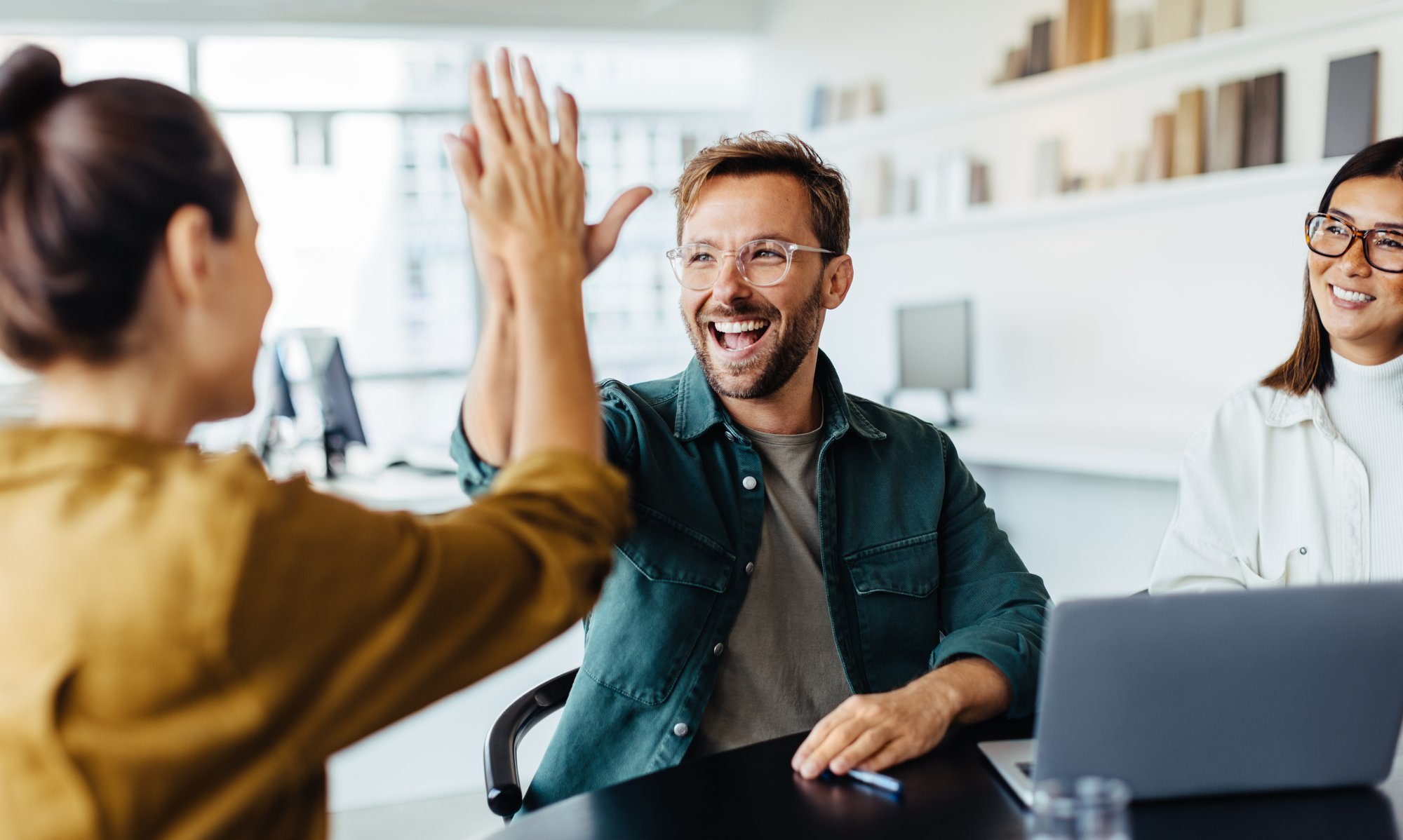 People sitting in a meeting high five